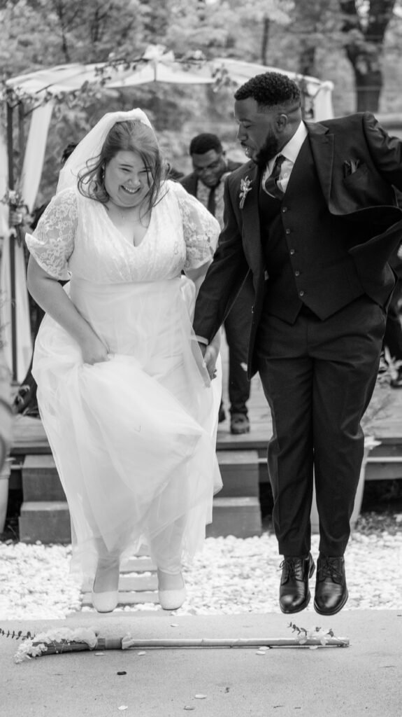 A man and woman on their wedding day jumping over a broom in Memphis