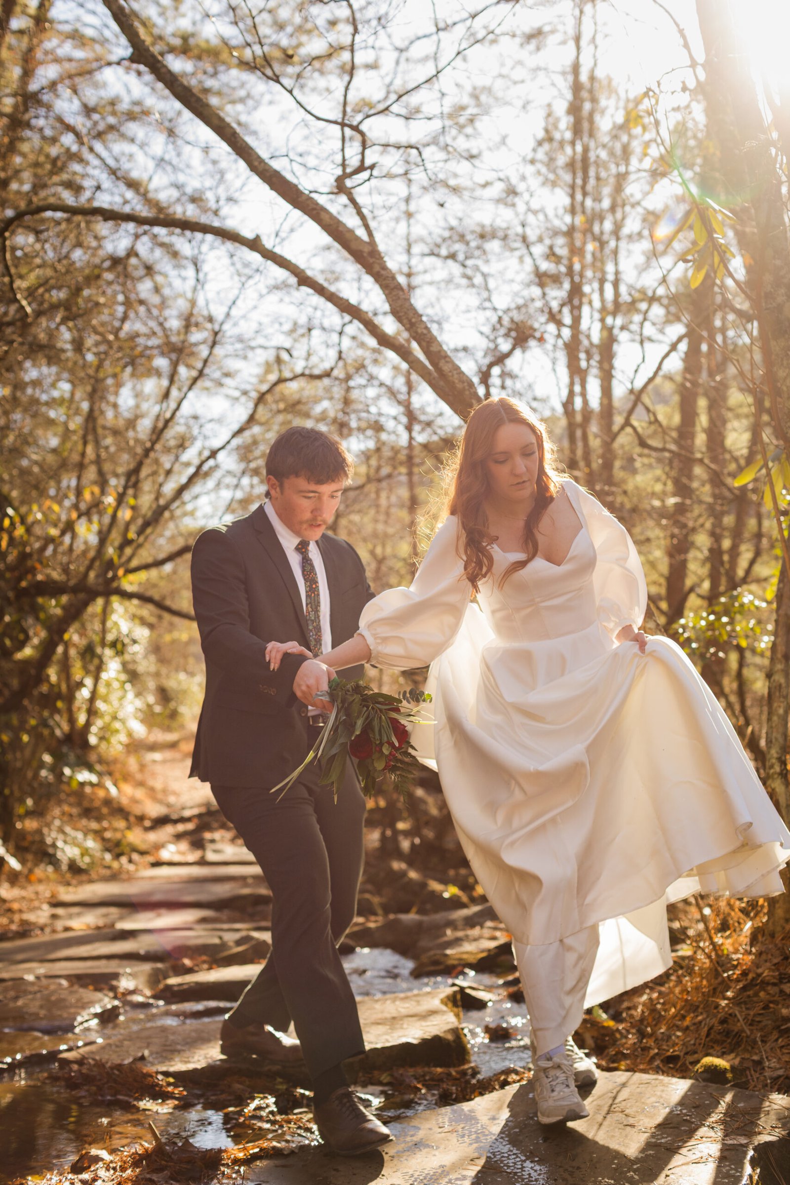 A bride and groom walking on their wedding day in the forest
