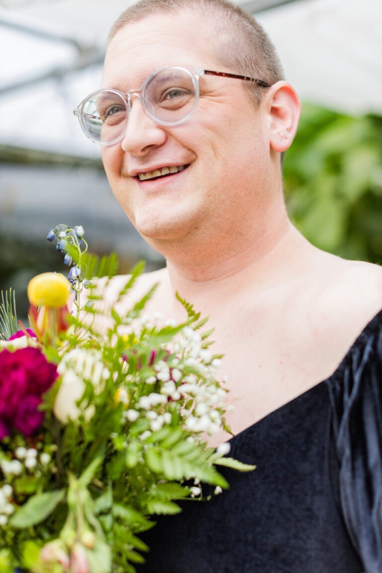 A woman holding a bouquet of flowers on her elopement day in the Atlanta Botanical Gardens