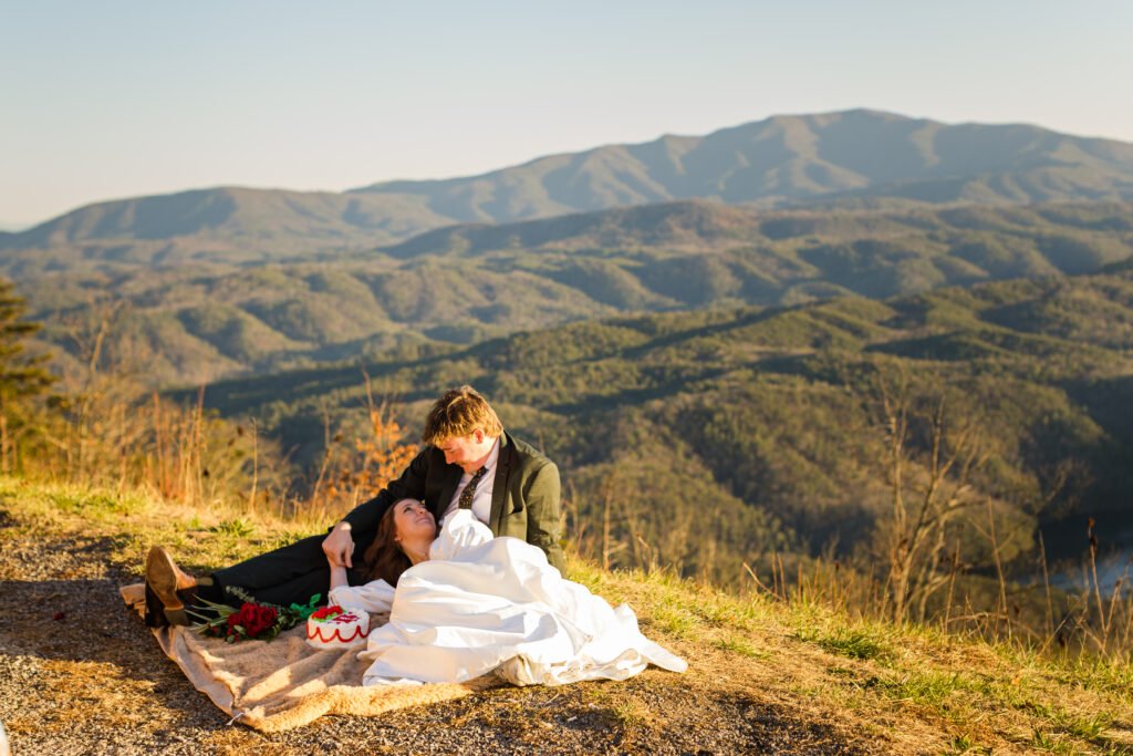IMG_6043 A couple on their elopement day eating a wedding cake while on the top overlook of the Cherokee National Forest